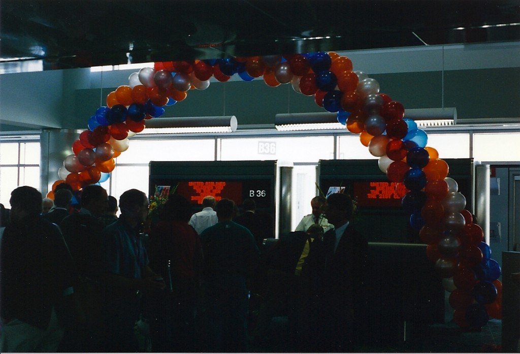 a group of people standing around a balloon arch