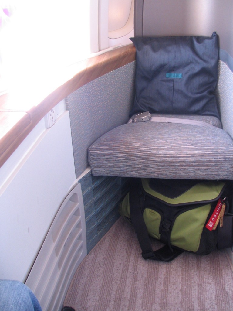 a seat with a pillow and a bag on the floor