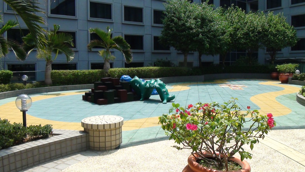 a green toy crocodile in a courtyard