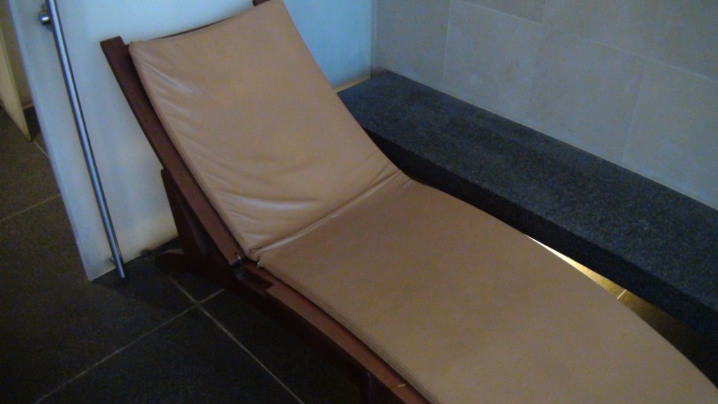 a tan chair next to a black tile floor