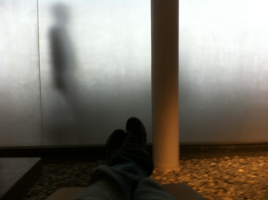 a person's legs and feet in front of a glass wall