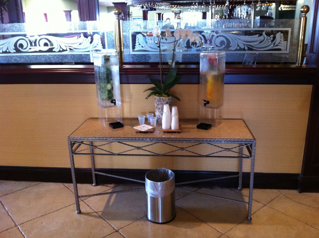 a table with a few water dispensers and a trash can