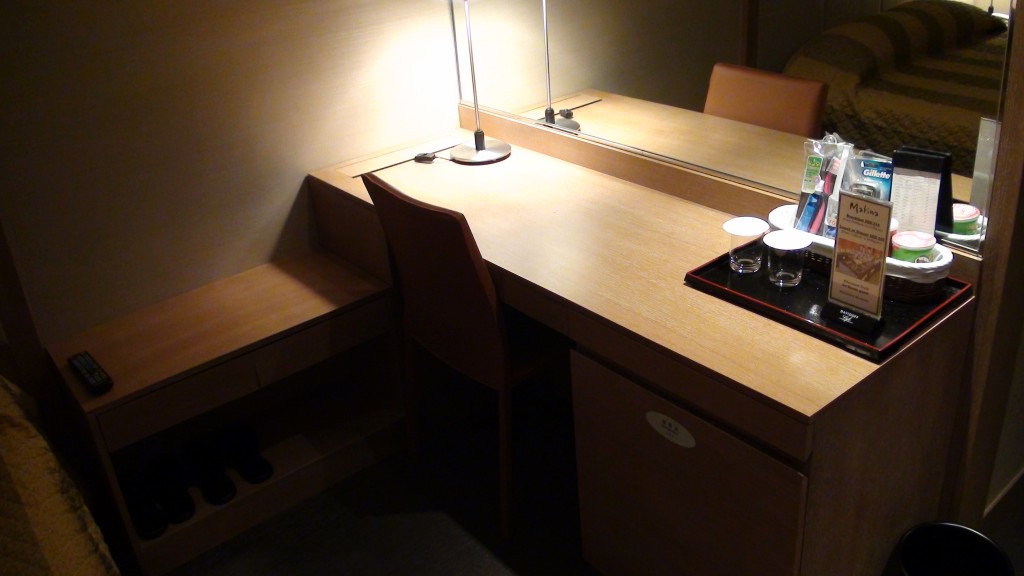 a desk with a table lamp and a table