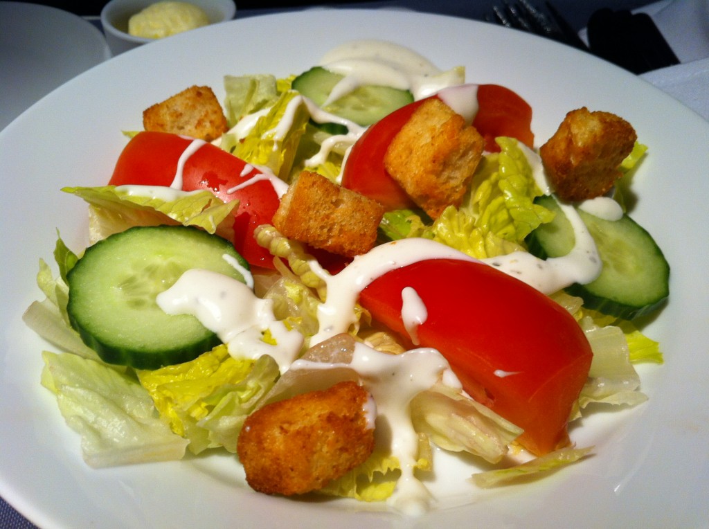 a salad with croutons and cucumbers on a plate
