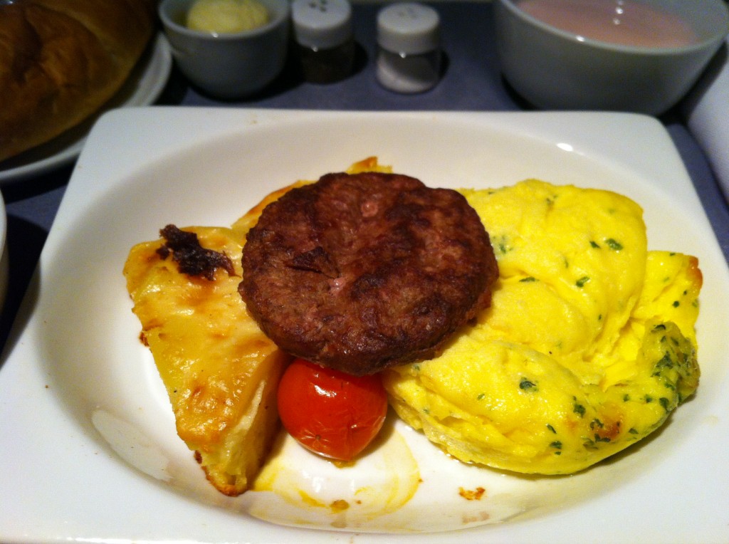 a plate of food with a hamburger and omelette