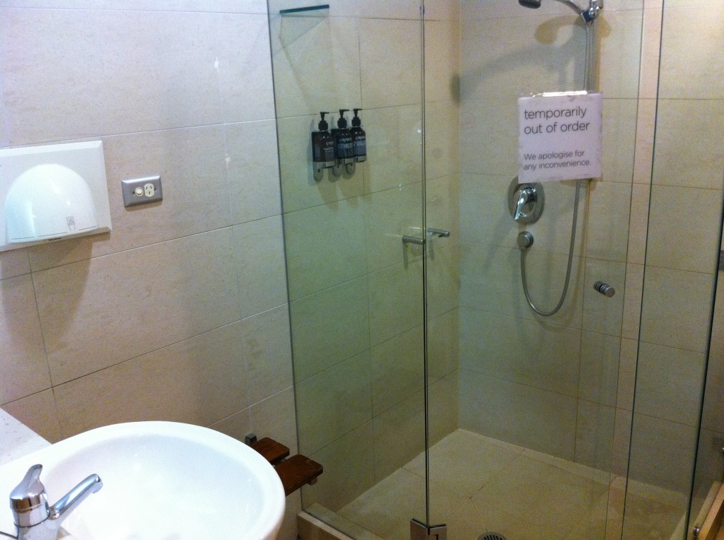 a shower with a sign on the wall