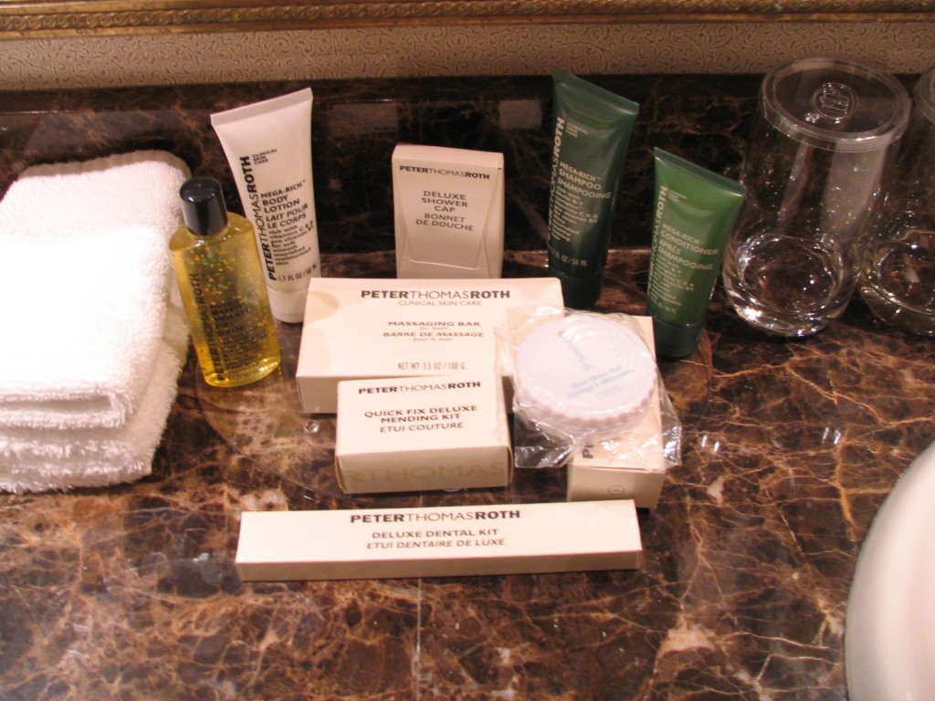 a group of toiletries and a glass on a marble counter