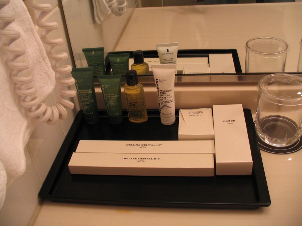 a tray with a variety of toiletries and a glass of water