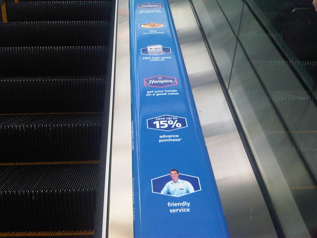 a blue sign on a escalator