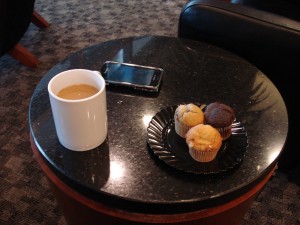 a cup of coffee and muffins on a black table