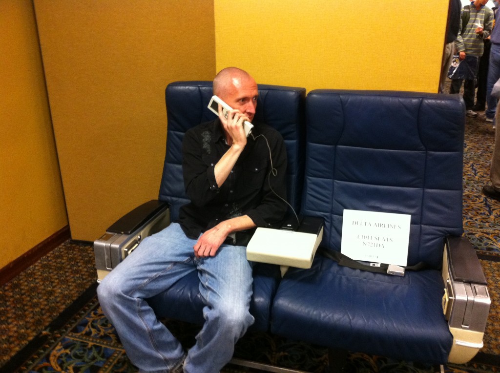 a man sitting on a couch talking on a phone