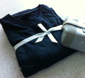a black shirt tied with a white ribbon next to a grey box