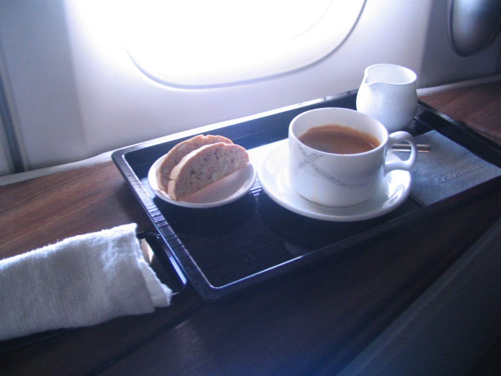 a tray with a cup of coffee and a piece of bread on it