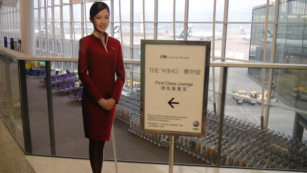 a woman in a red dress standing next to a sign
