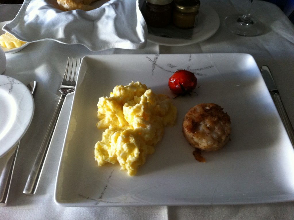 a plate of scrambled eggs and a tomato
