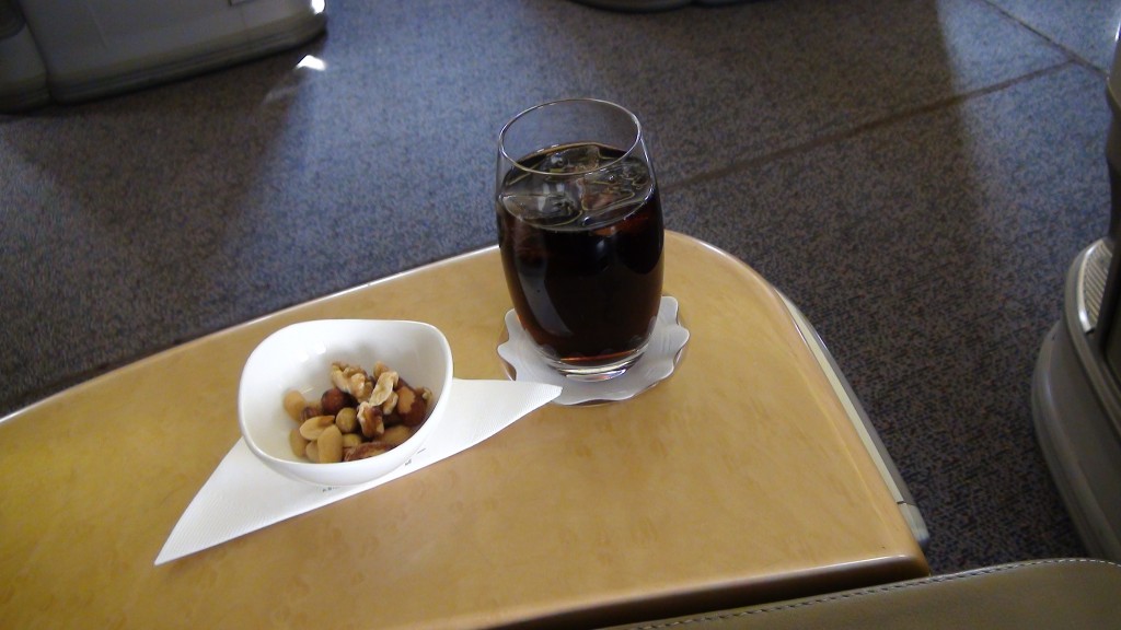 a glass of liquid and a bowl of nuts