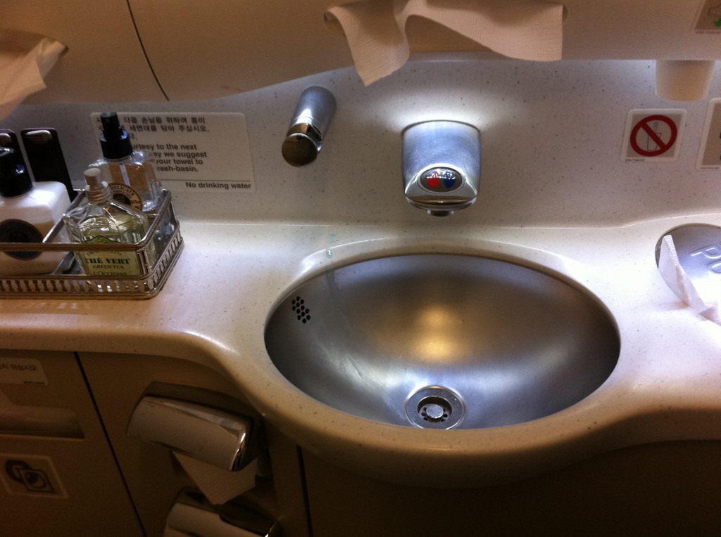 a sink with a soap dispenser and a bottle of liquid