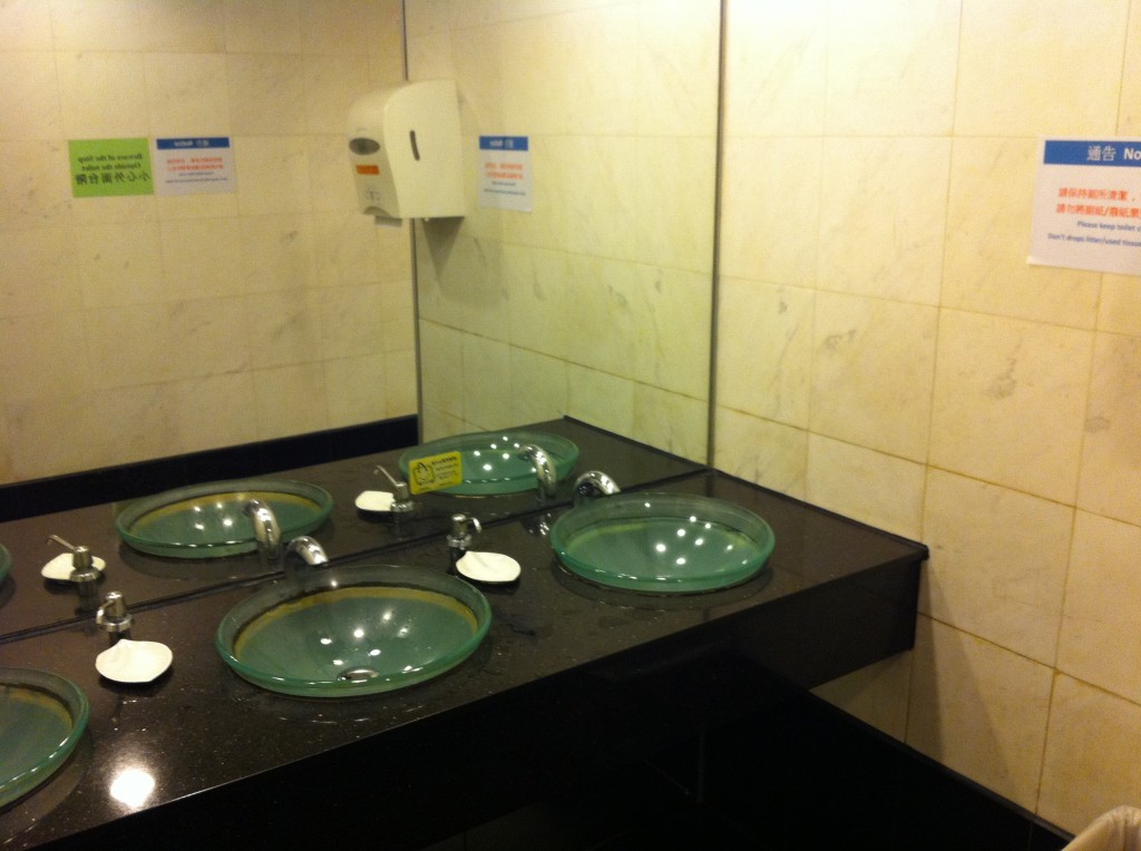 a bathroom with sinks and soap dispensers