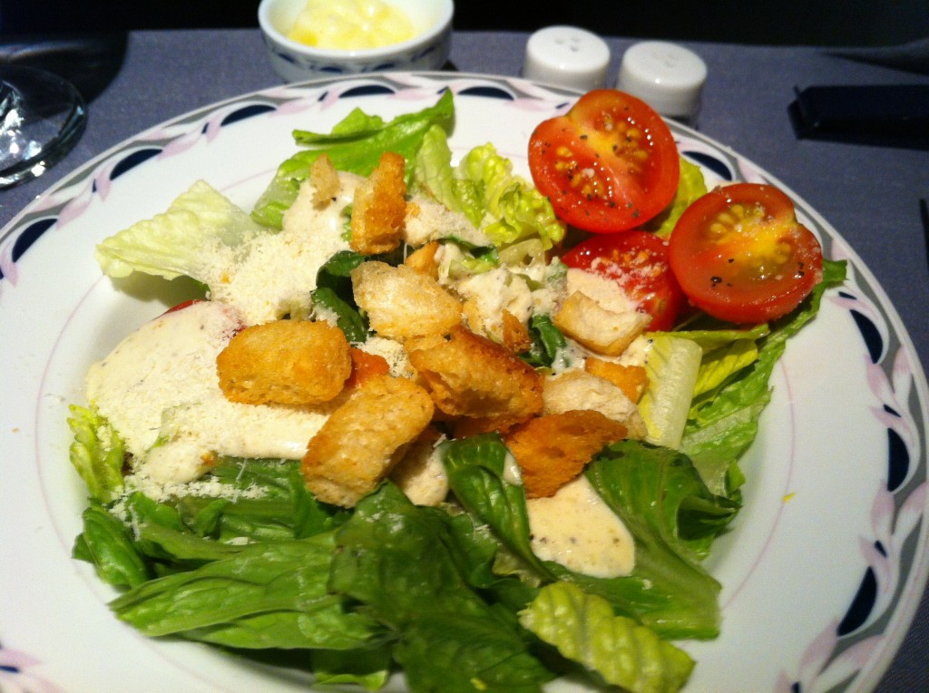 a salad with croutons and tomatoes