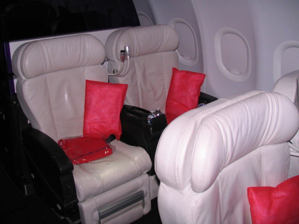 a white leather seats with red pillows