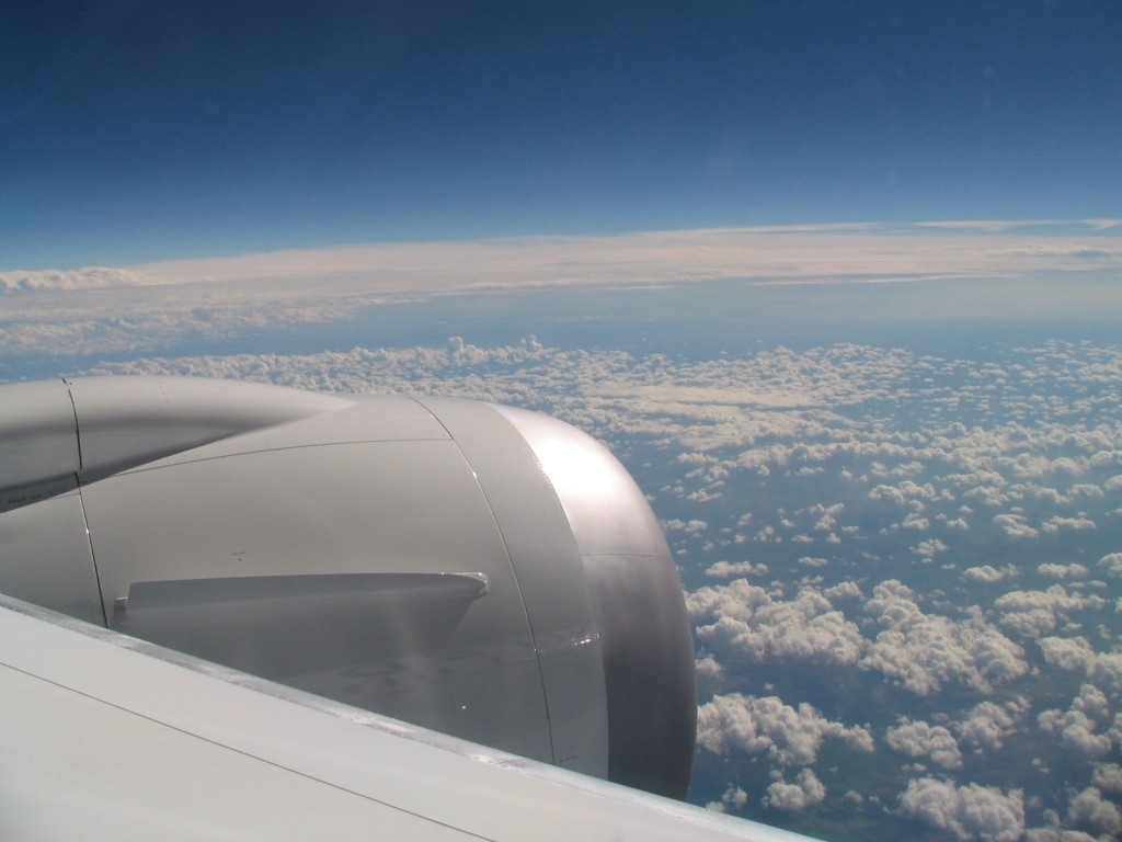 an airplane wing with clouds in the background