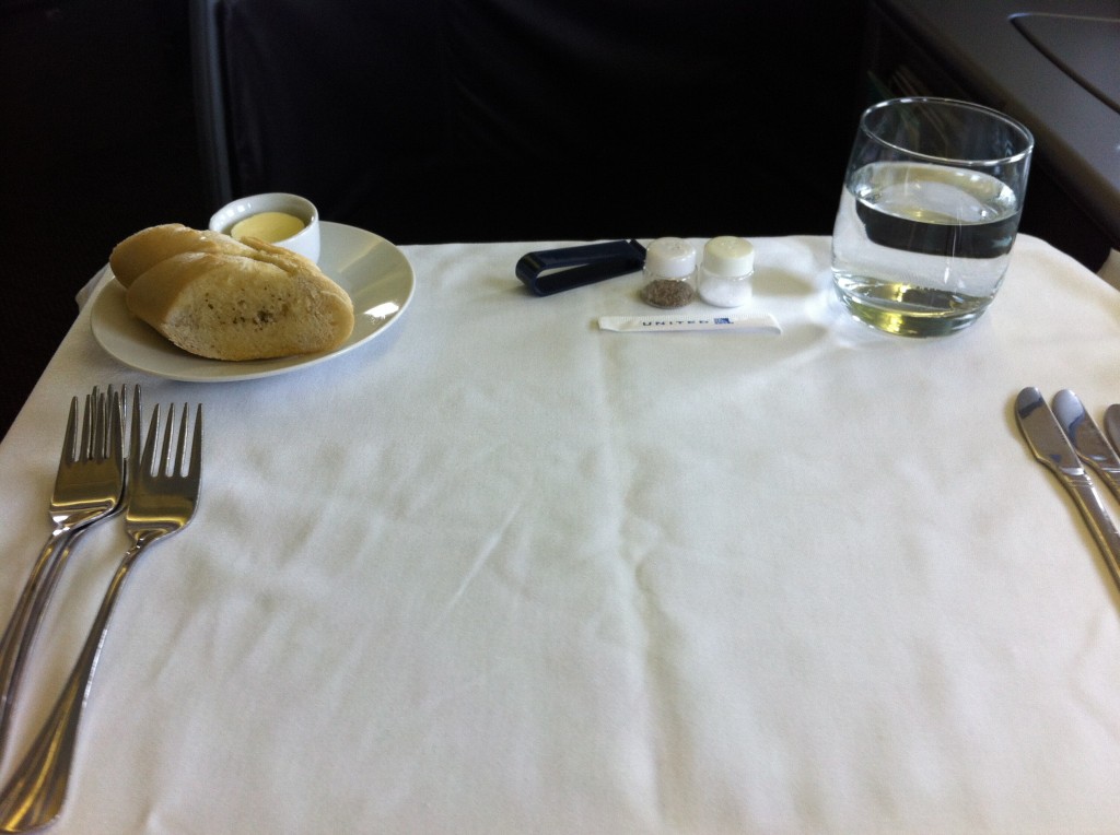 a plate of bread and a glass of water on a table