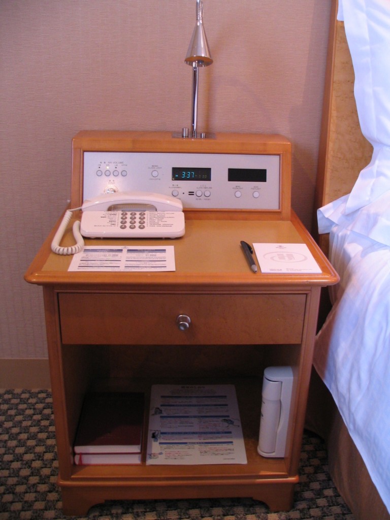 a telephone and a lamp on a nightstand