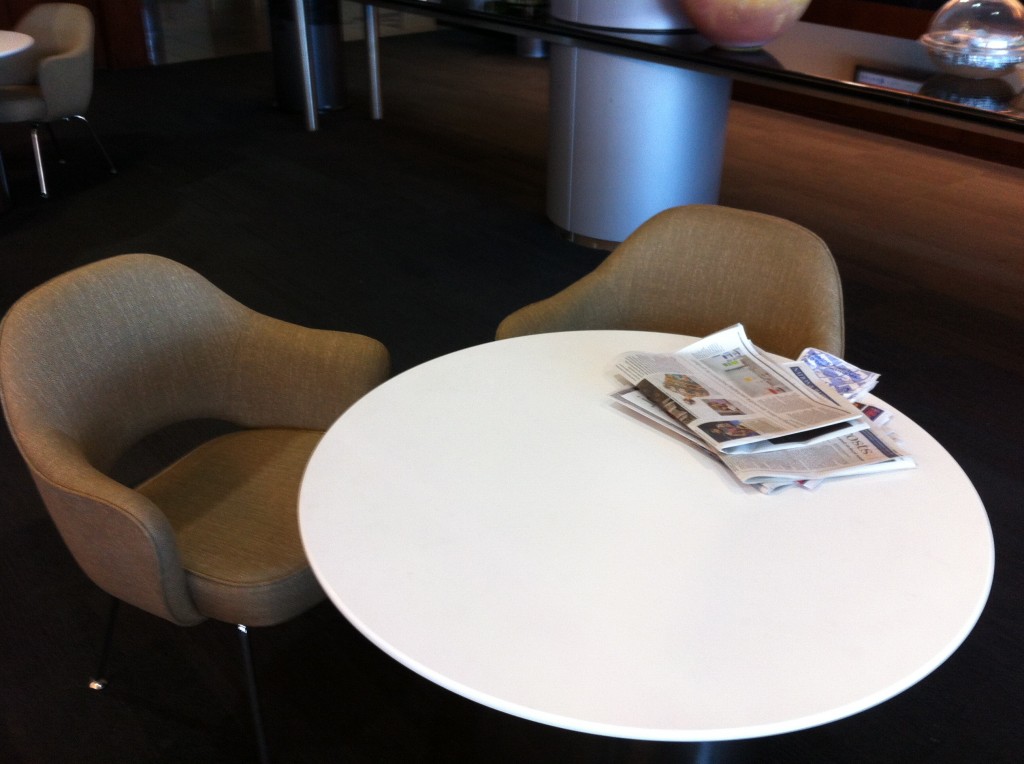 a white round table with newspapers on it