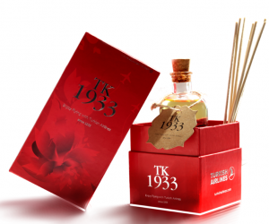 a red box with a bottle of oil and sticks