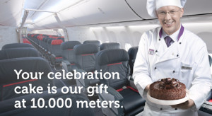 a chef holding a chocolate cake in an airplane