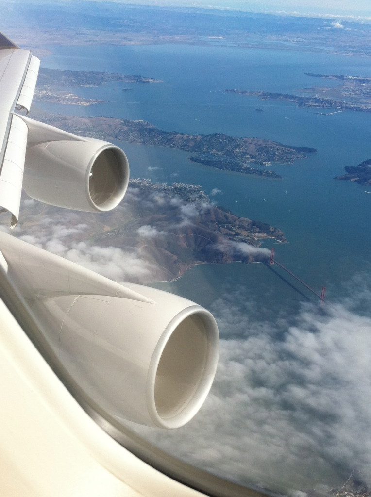 an airplane wing with water and land below