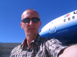 a man taking a selfie in front of an airplane